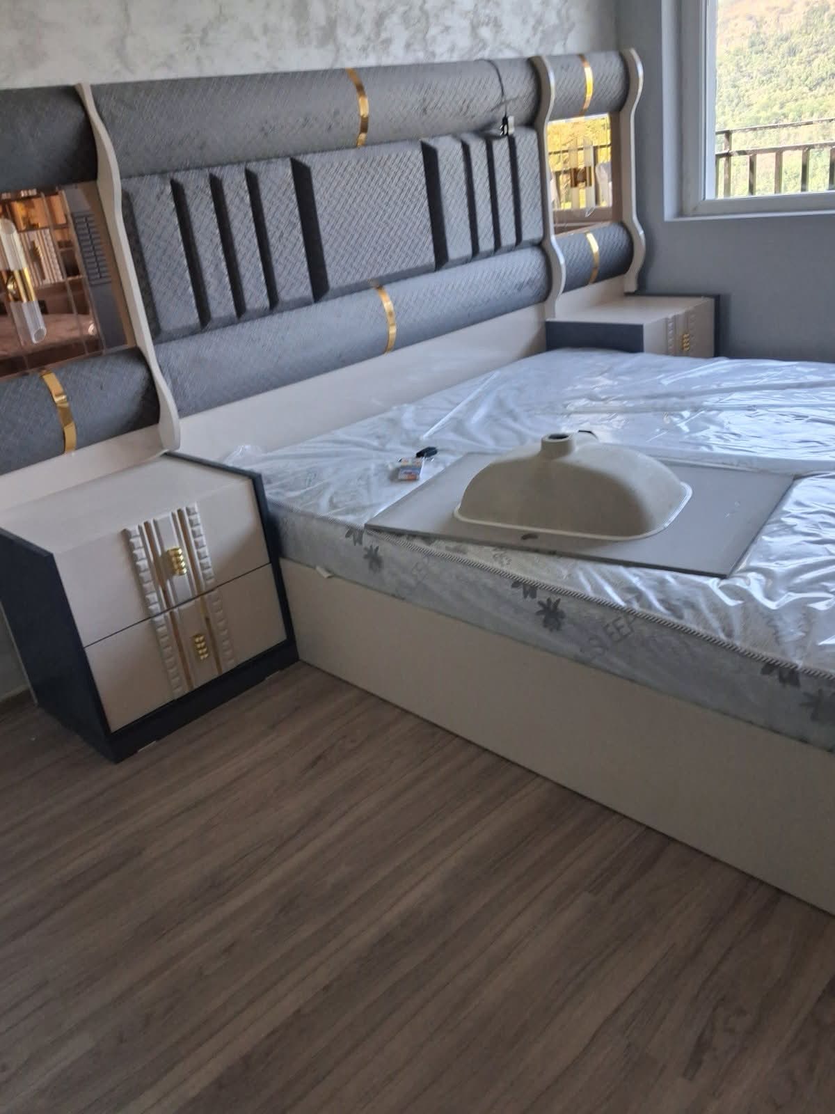 Grey upholstered bed suite with gold trim